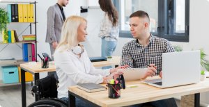 A man and a disabled woman talking in an office setting