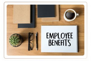 Office items and a note on the table stating employee benefits