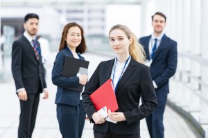Four employees standing proudly outside the company building