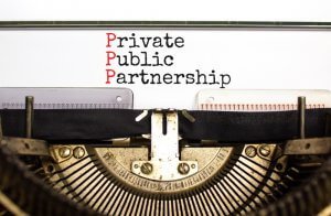 An old-fashioned typewriter with the text "Private Public Partnership" typed on paper. The first letters of each word ("P") are highlighted in red, showcasing the talent behind this design, while the rest of the text is in black.