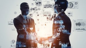 Two silhouetted individuals in business attire shake hands with a digital overlay of various AI icons and graphics superimposed on their figures. The background features a network of interconnected nodes, symbolizing connectivity and technological advancement.