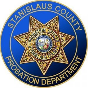 A circular badge with a gold star in the center, reading "Stanislaus County Probation Officer" and "The Great Seal of the State of California." The blue border says "Stanislaus County Probation Department.