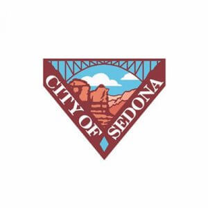 A triangular logo with "City of Sedona" text, featuring red rock formations, blue sky, white clouds, and a bridge above the landscape.