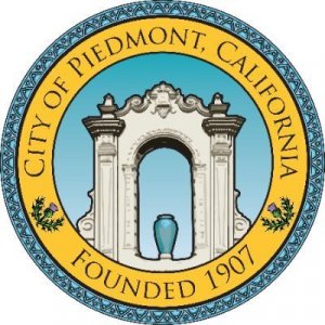 Circular seal of the City of Piedmont, California, with a decorative arch and vase in the center, surrounded by yellow and blue borders, and text stating "City of Piedmont, California, Founded 1907.
