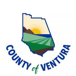 Logo of Ventura County featuring a stylized map outline with hills, fields, and the sun over water inside. The text “County of Ventura” curves below in blue and green letters.