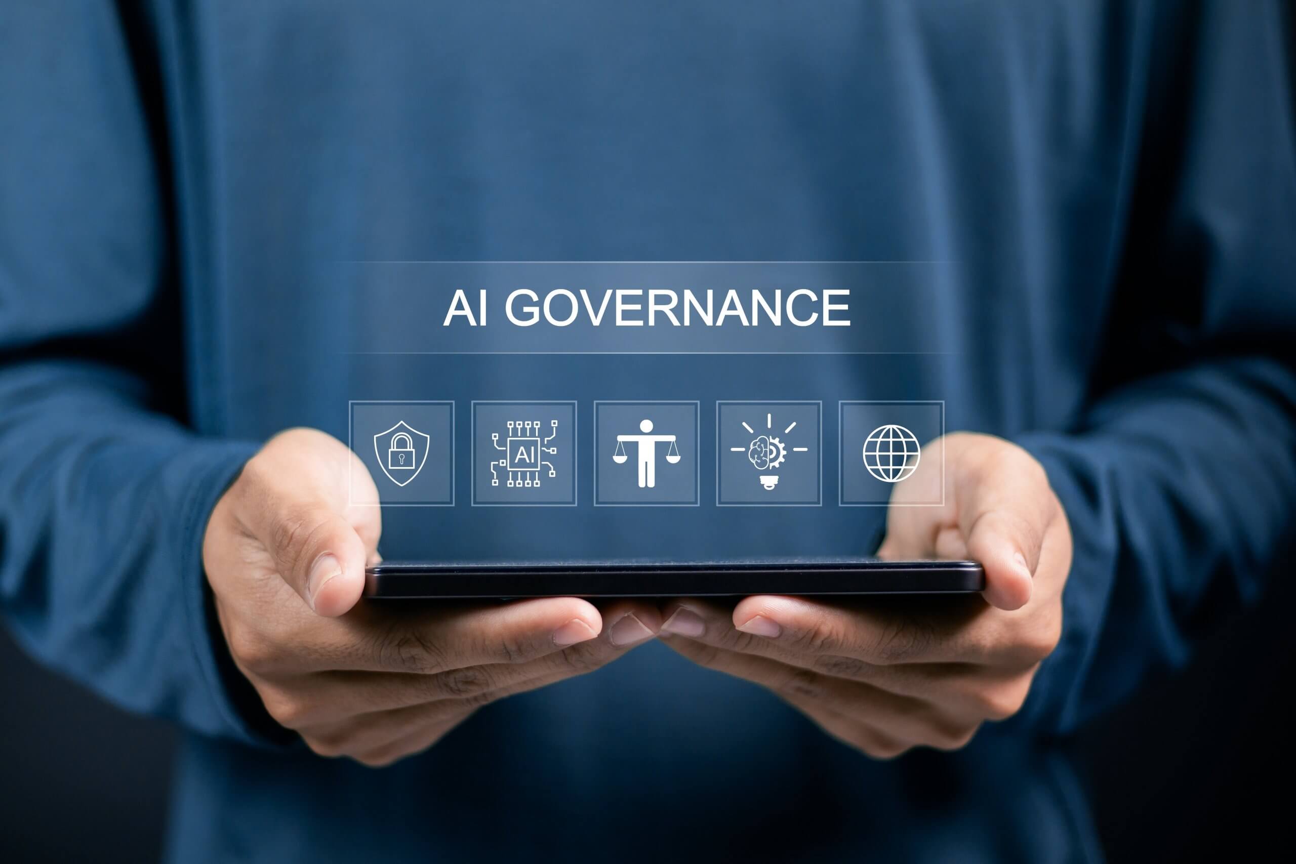 A person holding a tablet with digital graphics displaying "AI Governance" and icons representing AI security, compliance, innovation, and global connectivity. A person holding a tablet with digital graphics displaying "AI Governance" and icons representing AI security, compliance, innovation, and global connectivity.