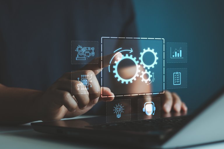 A person uses a laptop, interacting with a transparent virtual screen displaying icons of gears, charts, and checklists—symbolizing automation and digital processes in public service.
