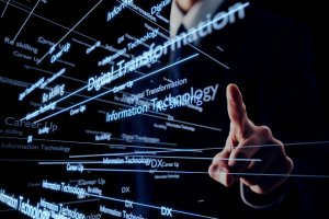 A person in a suit points at floating digital words like “Digital Transformation” and “Information Technology” on a virtual screen, symbolizing technology, innovation, digital progress, and the rise of government talent in the tech sector.
