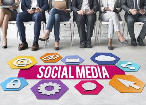 Six people sit in a row using digital devices. In front of them are colorful hexagons with social media icons, a pink "SOCIAL MEDIA" banner in the center, highlighting the influence of government on online interactions.