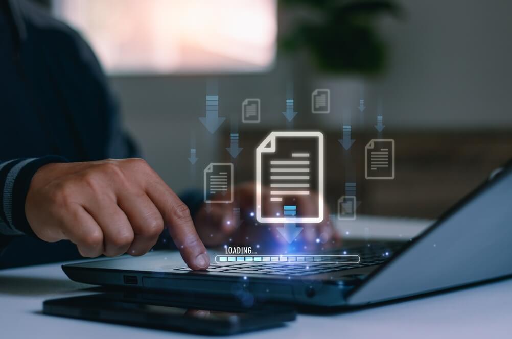 Businessman,Using,Laptop,To,Manage,Digital,Document,With,File,Transfer, A robotic hand with metallic fingers touches the illuminated trackpad of a laptop keyboard, symbolizing artificial intelligence, technology integration, and the evolving future of government workers.