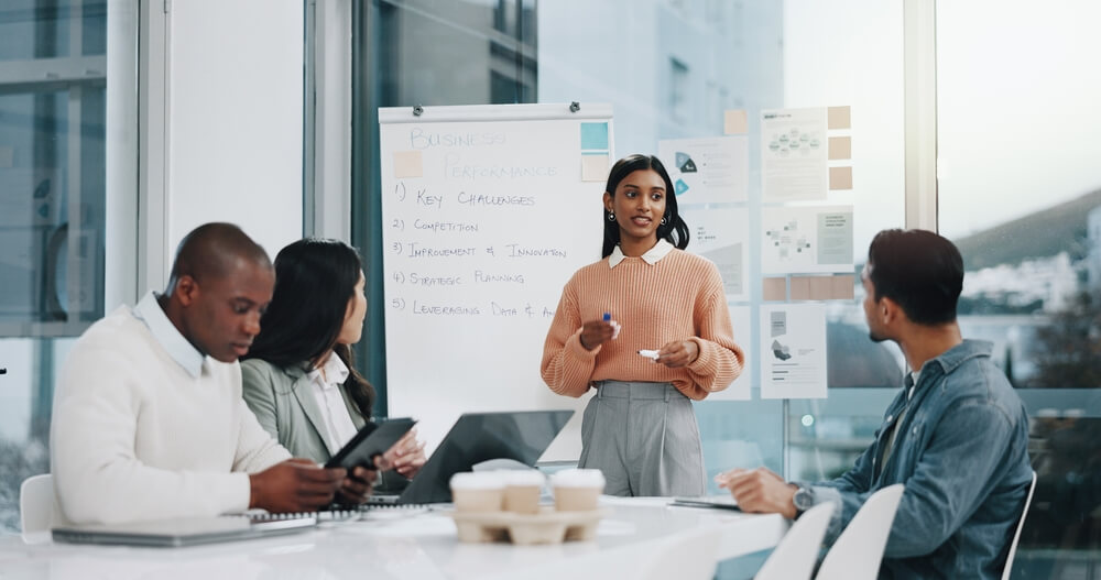 Training,,Chart,And,Team,Meeting,In,Office,,Woman,Manager,And A person in a suit lifts a wire cage off a small figurine dressed in business attire, symbolizing freedom or release from confinement in the context of recruitment, on a white surface.