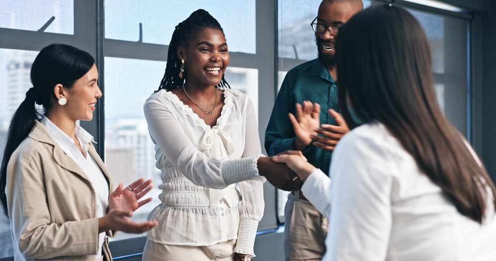Business,People,,Team,And,Handshake,With,Applause,For,Partnership,,Success A person in a suit lifts a wire cage off a small figurine dressed in business attire, symbolizing freedom or release from confinement in the context of recruitment, on a white surface.